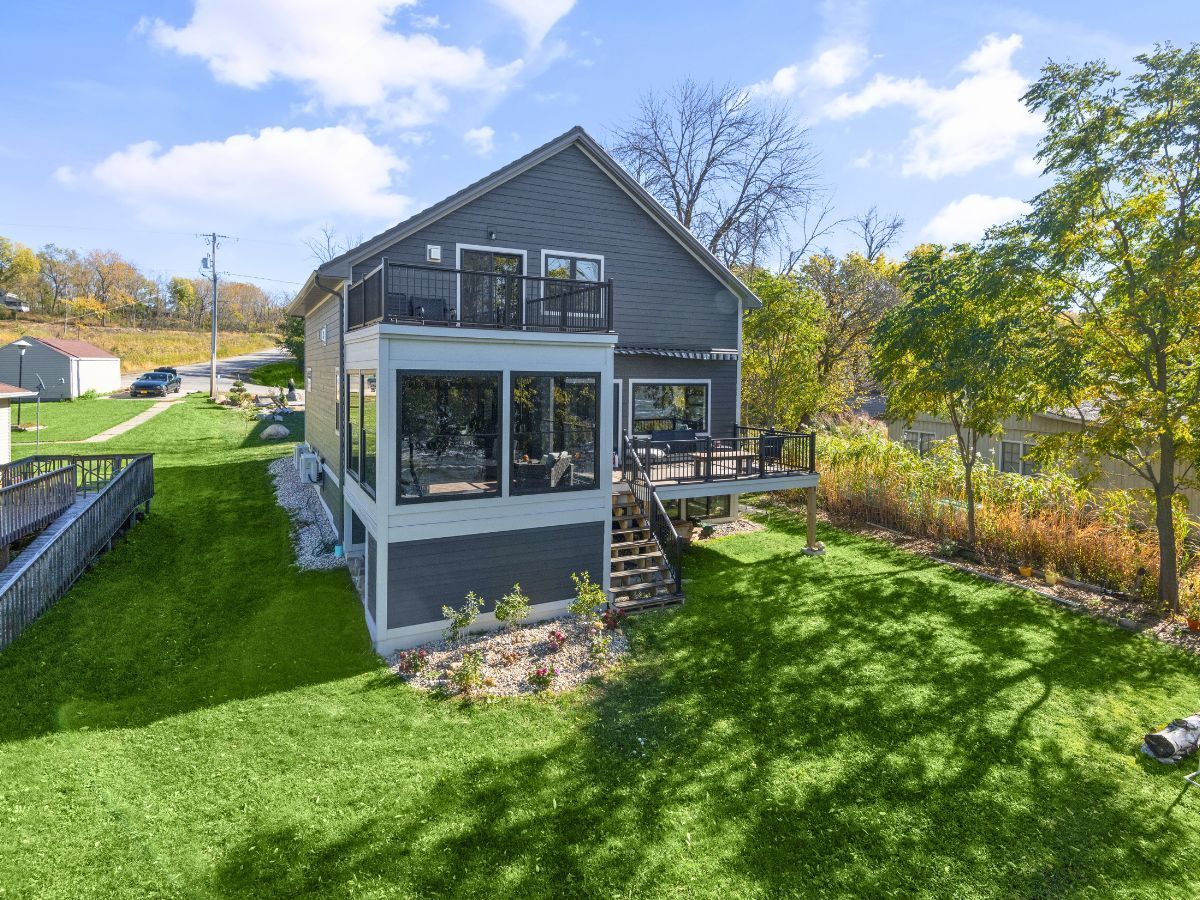 An aerial view of a house with a large lawn in front of it.