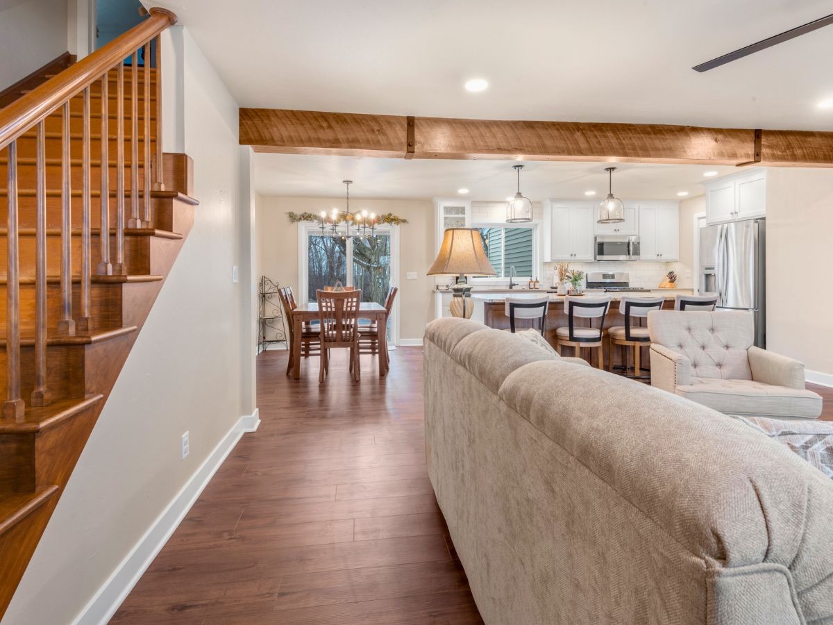 A living room with a couch and stairs leading to the kitchen and dining room.
