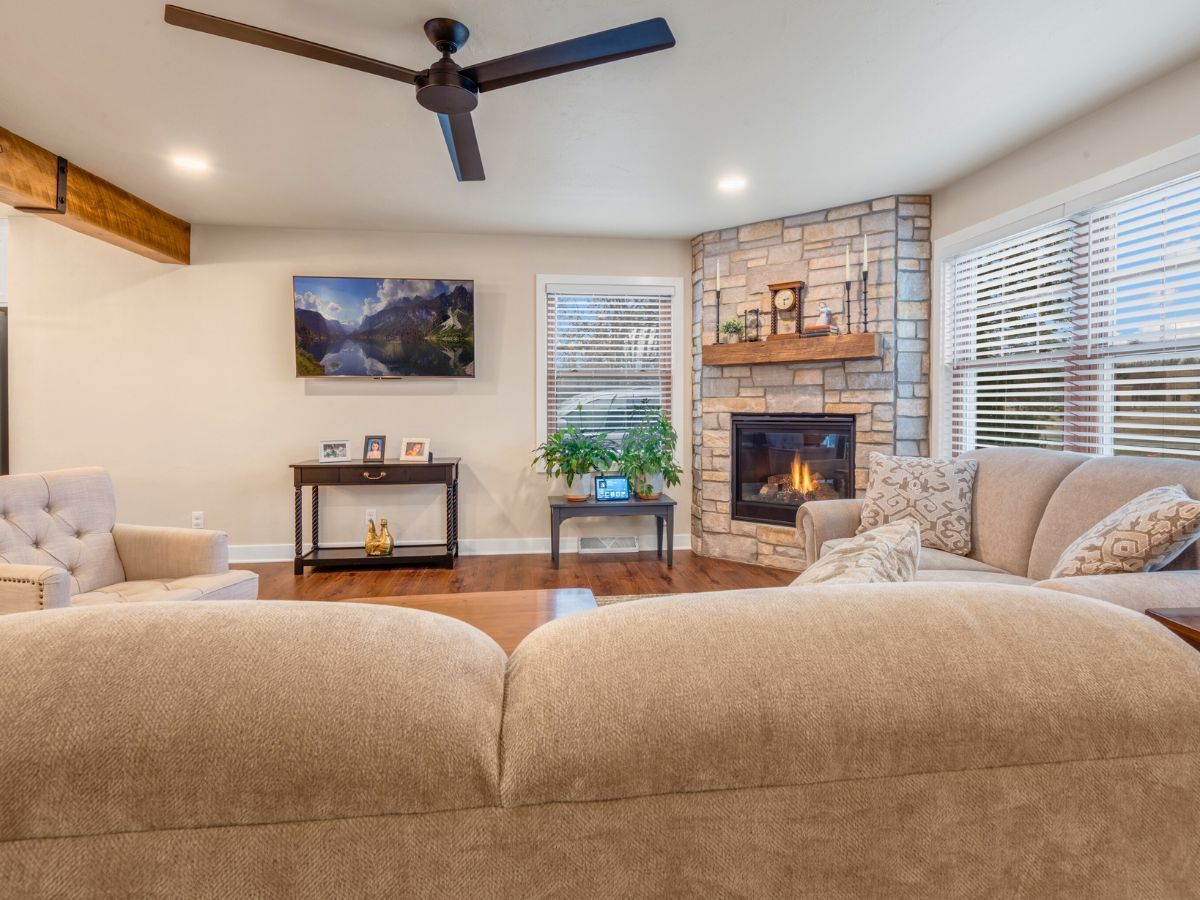A living room with a fireplace and a ceiling fan