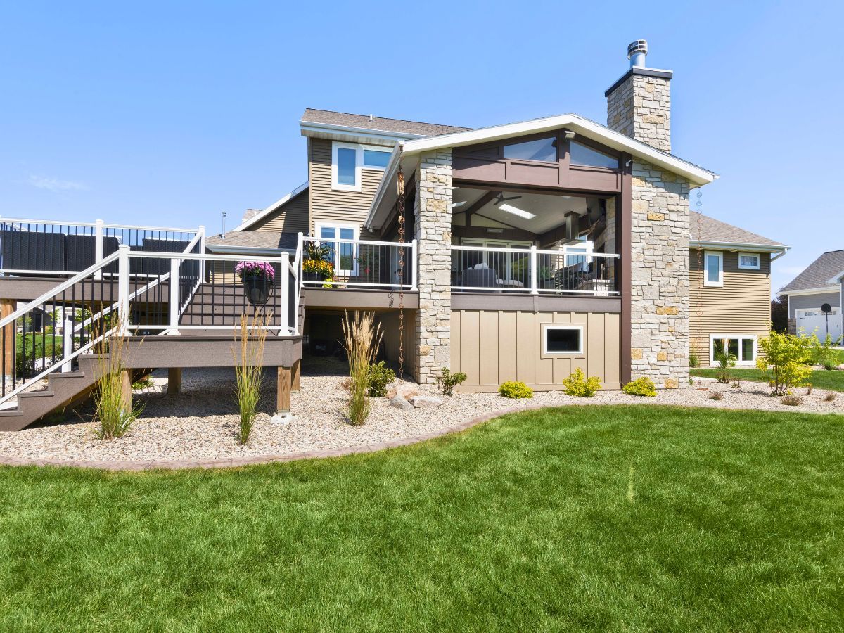 The back of a house with a large deck and stairs.