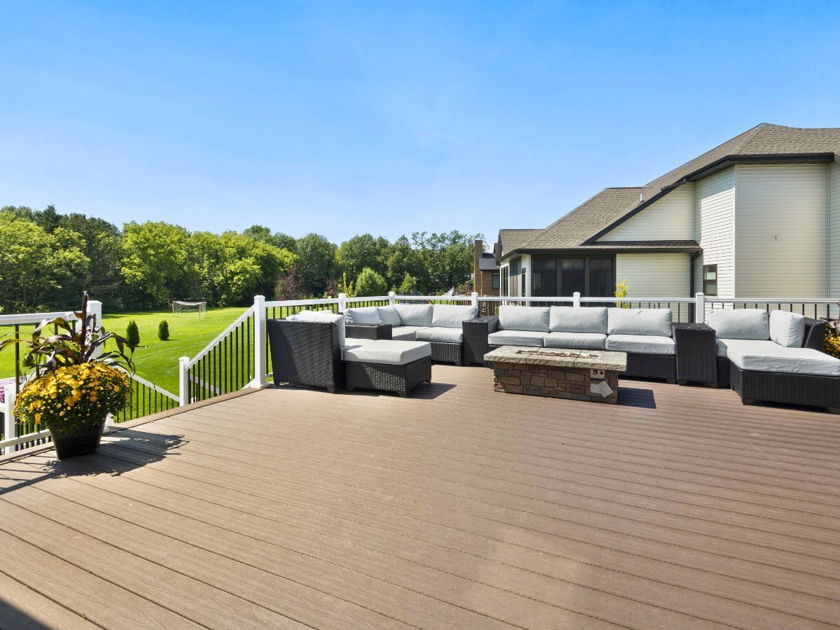 There is a large deck with a lot of furniture on it.