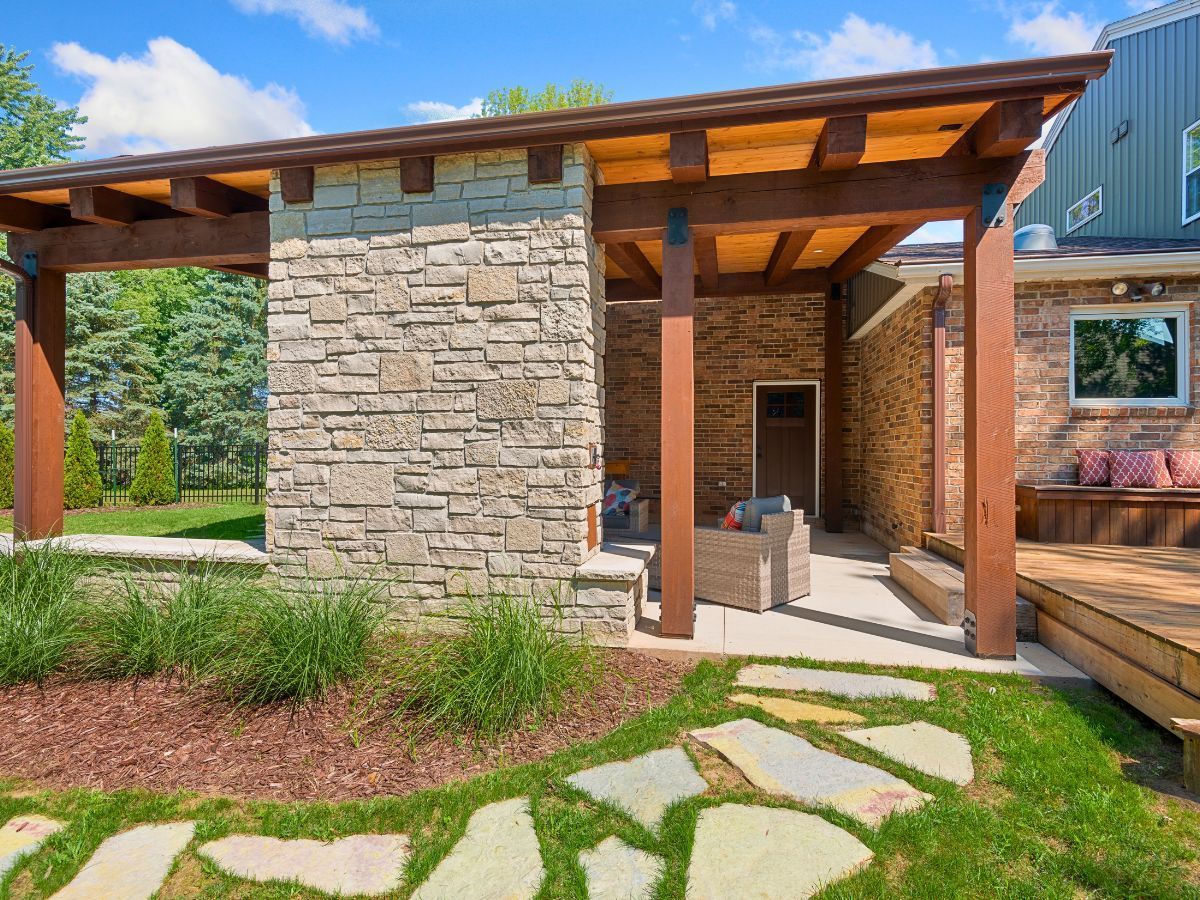 A stone building with a wooden pergola over it