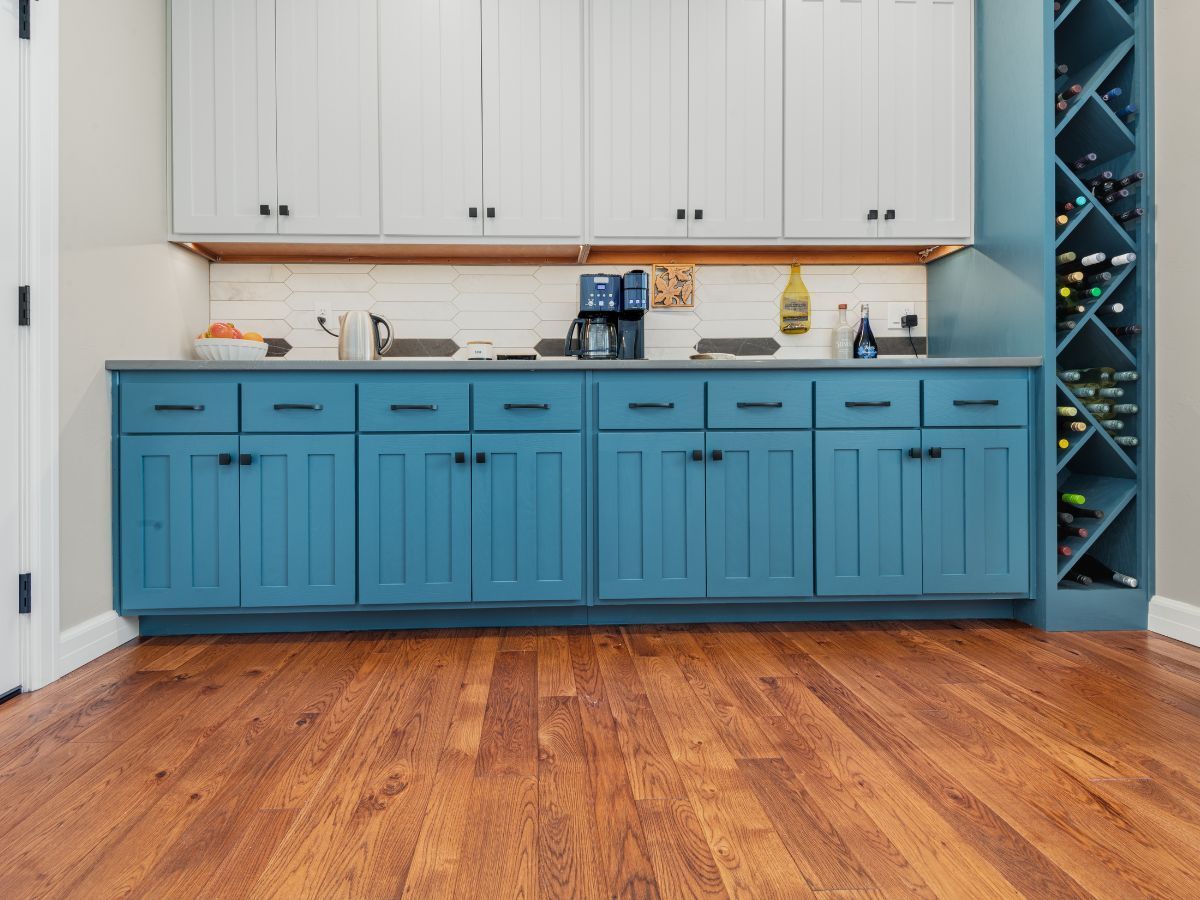 A kitchen with blue cabinets and a wine rack