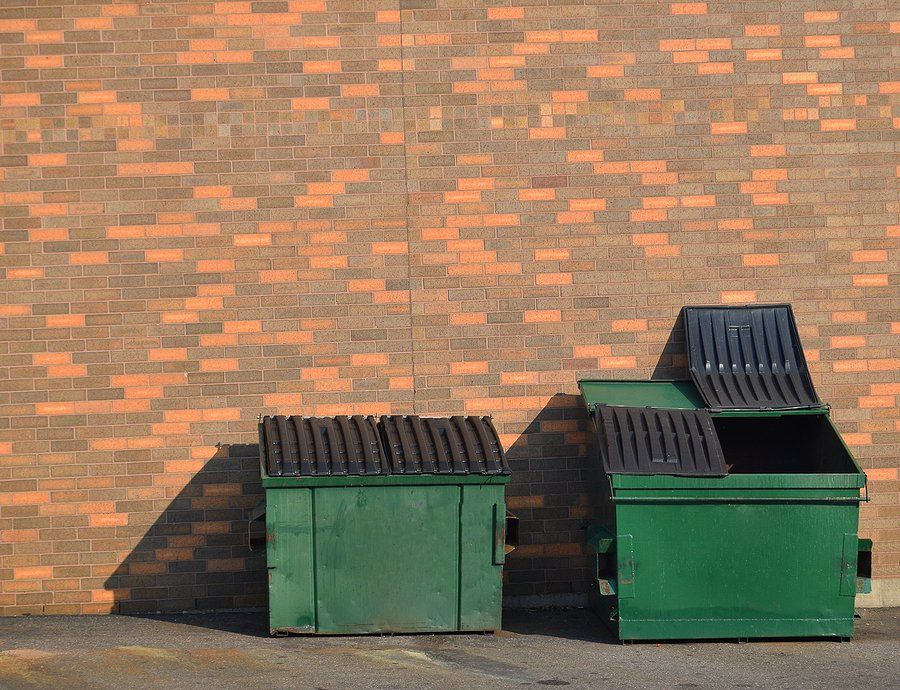 two dumpsters beside the wall