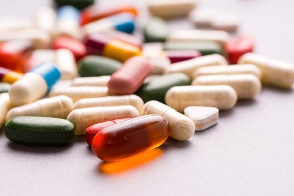 Assorted colorful capsules and tablets scattered on a white surface