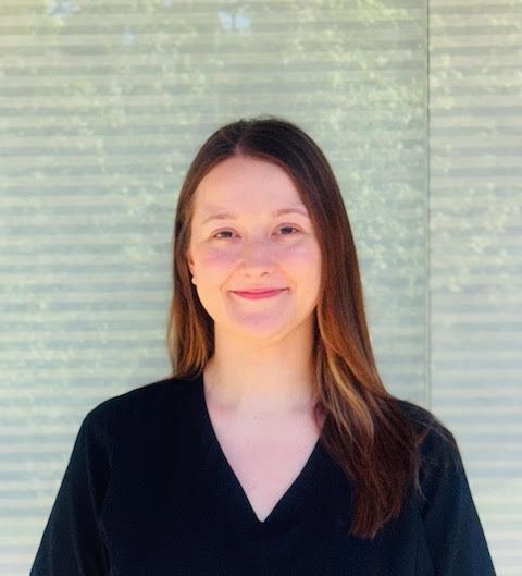 A woman in a black shirt is smiling for the camera