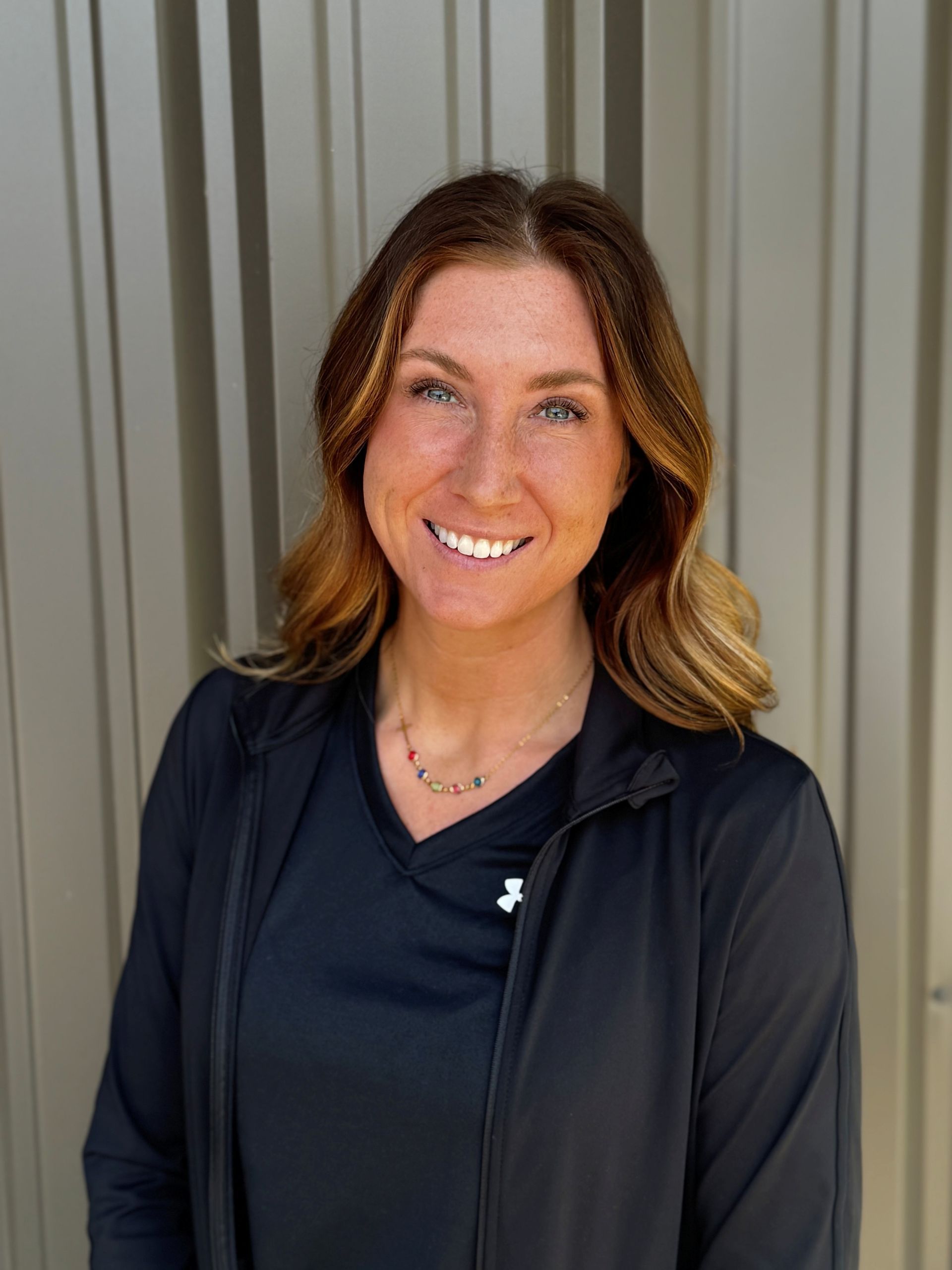 A woman in a black shirt is smiling for the camera
