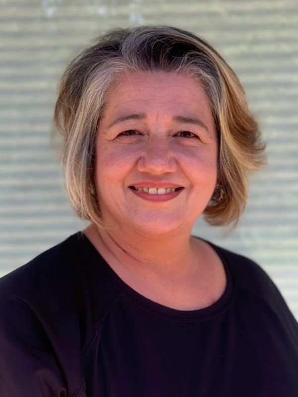 A woman in a black shirt is smiling for the camera