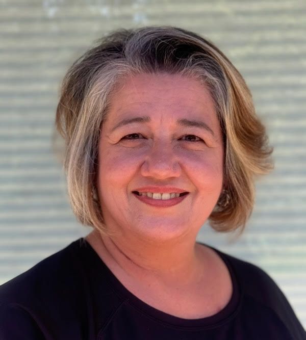 A woman wearing a black shirt is smiling for the camera