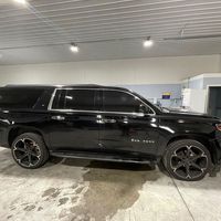 A black suv is parked in a garage.