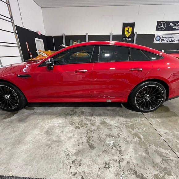 A red sports car is parked in a garage.