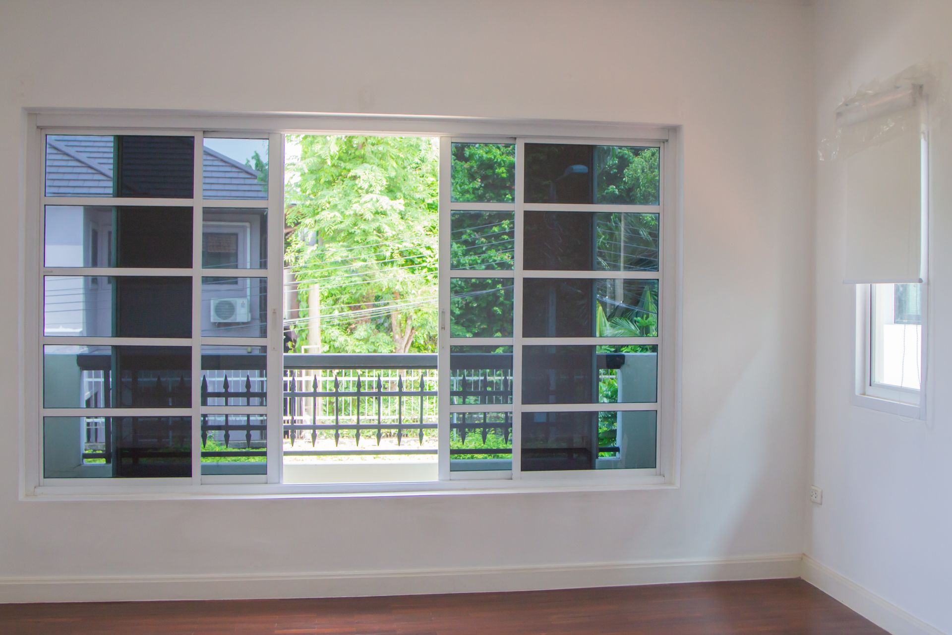 An empty room with a large window and a balcony