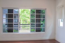 An empty room with a large window and a balcony