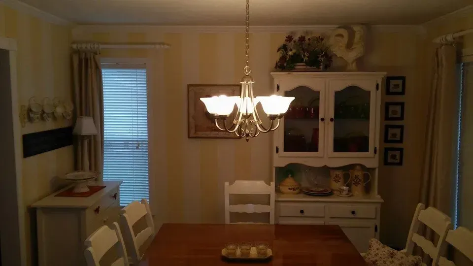 A dining room with a table and chairs and a chandelier
