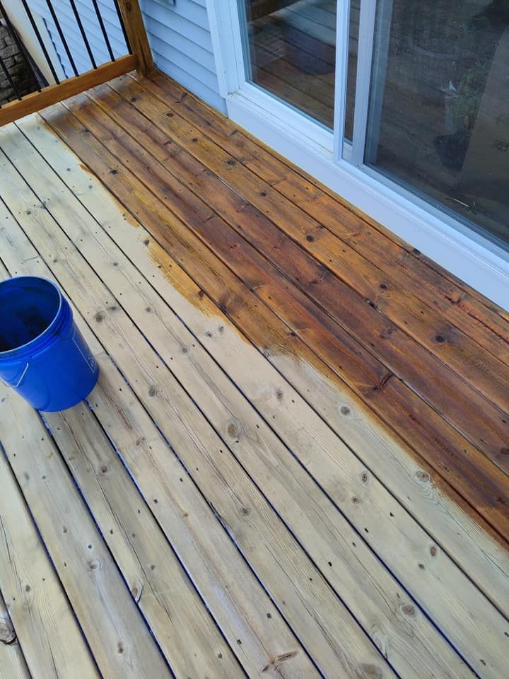 A blue bucket is sitting on a wooden deck next to a sliding glass door.