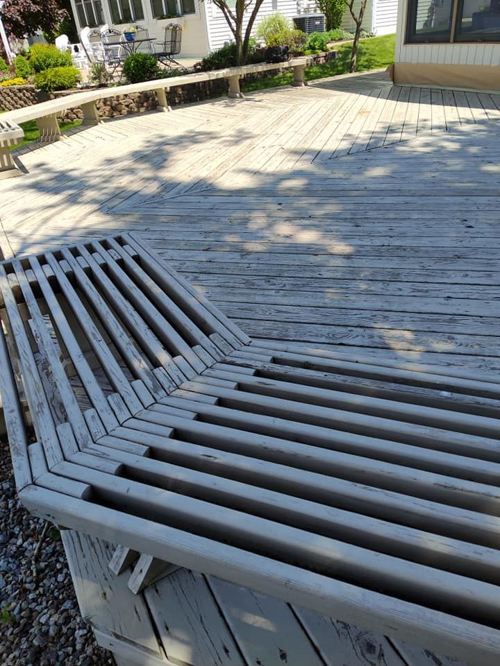 A wooden deck with a bench in the middle of it.