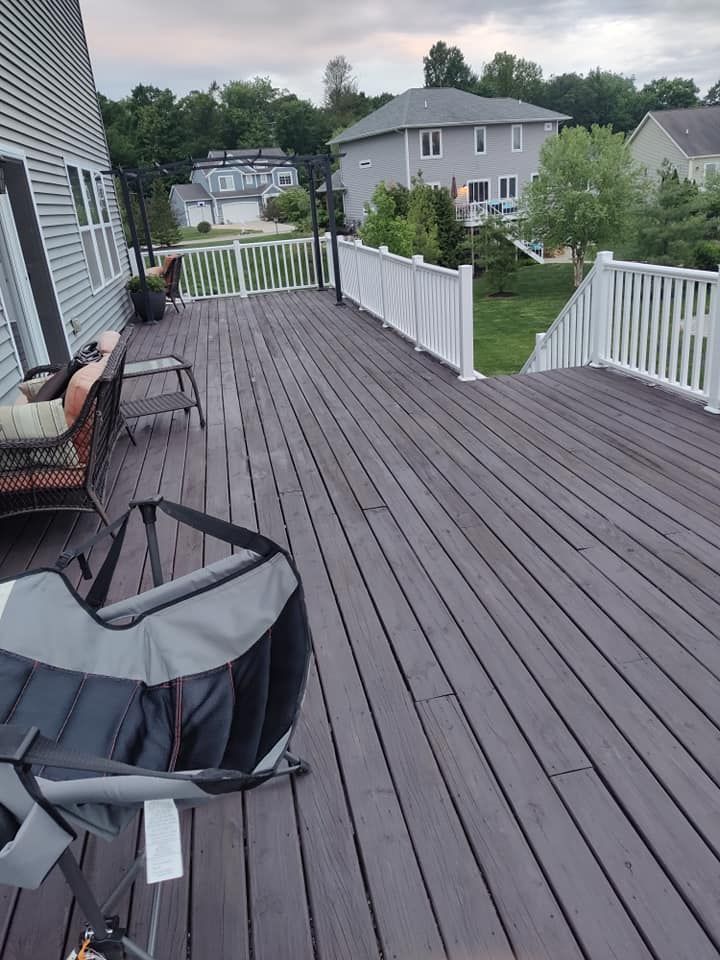 A large wooden deck with a chair and a bag on it.