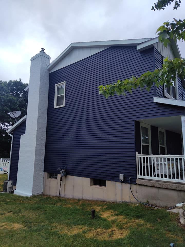 A blue house with a white chimney on the side