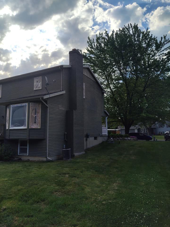 A house with a chimney and a tree in front of it
