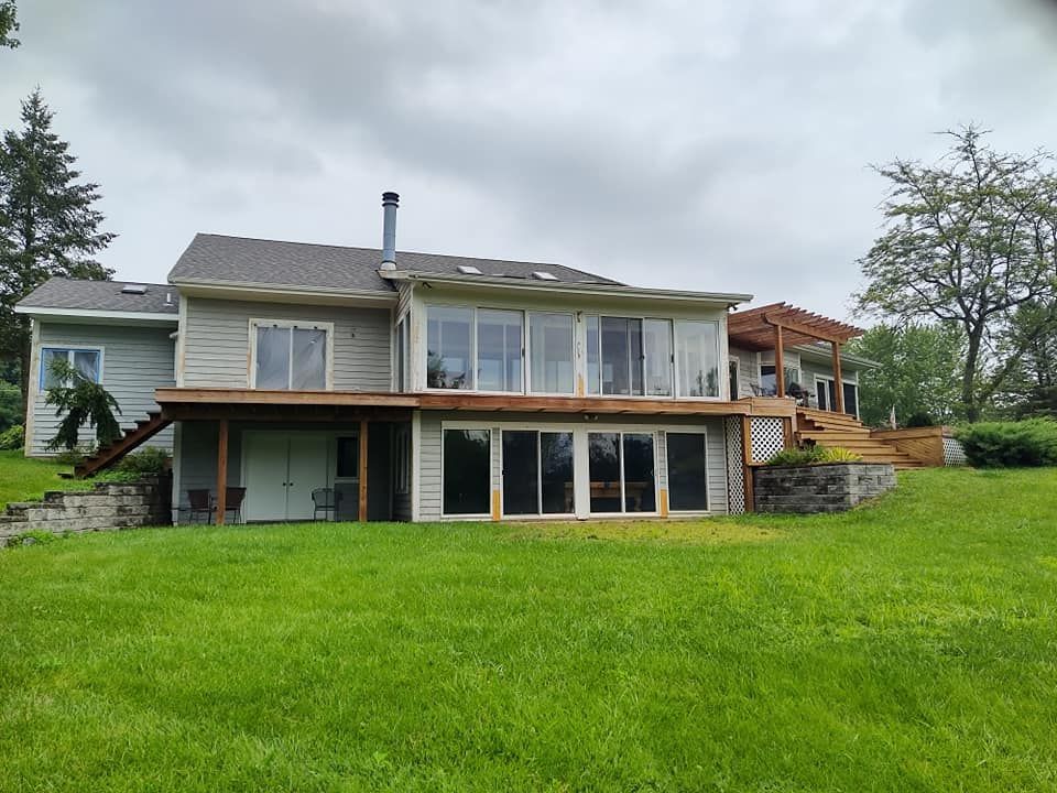 A large house with a lot of windows and a large lawn in front of it.