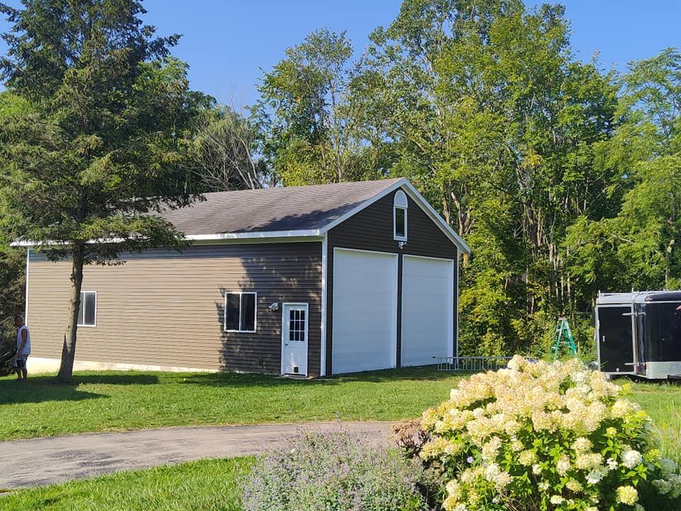 A garage with a trailer parked in front of it