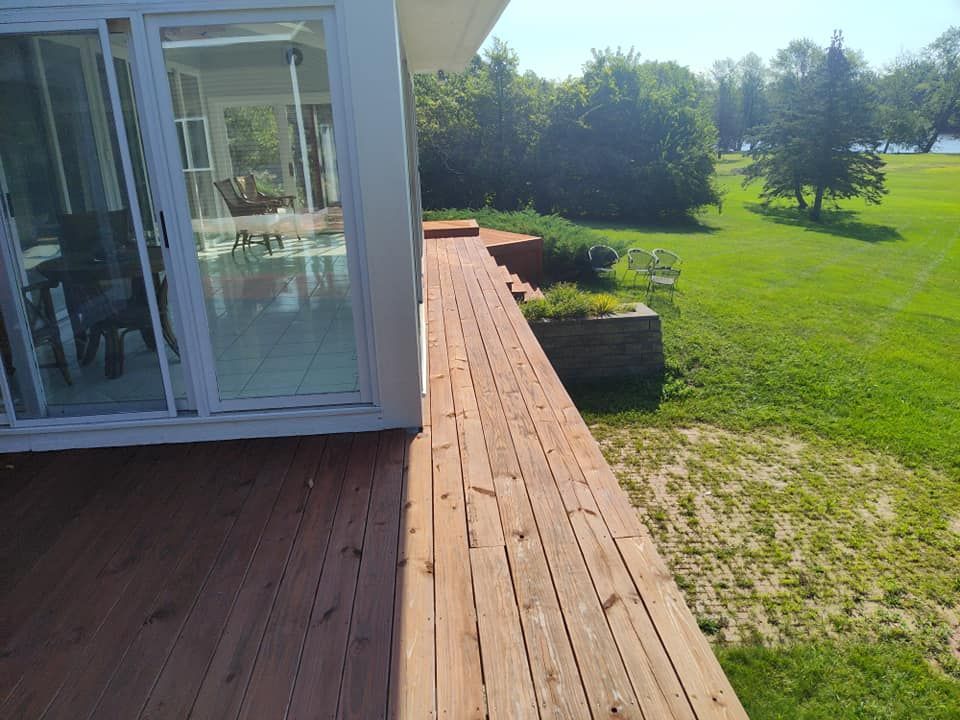 A wooden deck with a sliding glass door leading to a house.