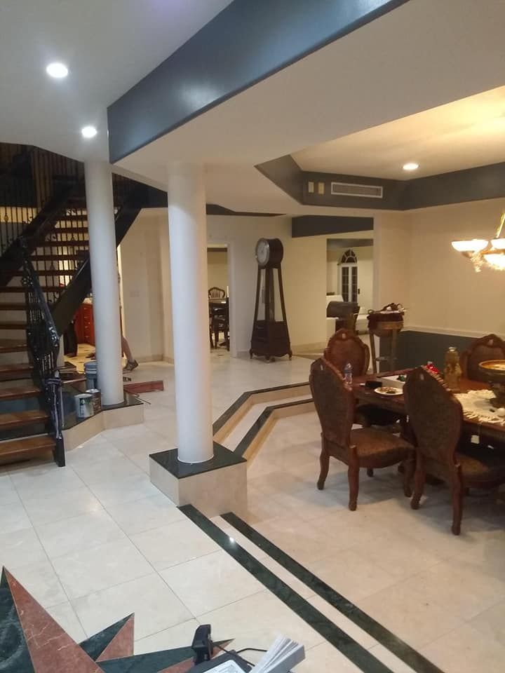 A living room with a table and chairs and a clock