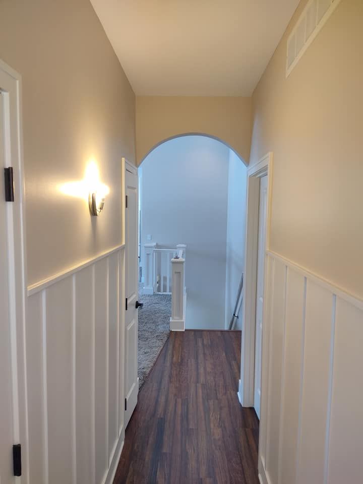 A hallway with wooden floors and white walls