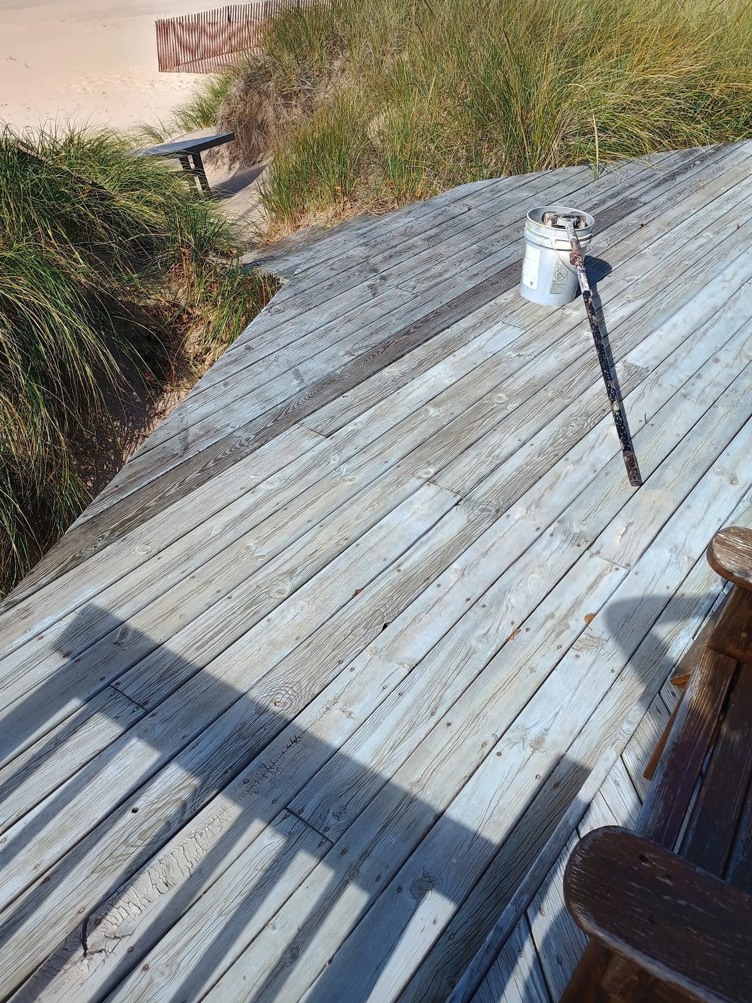 A wooden deck with a chair and a can on it.