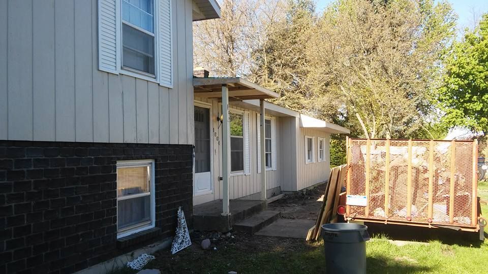 A house with a dumpster in front of it