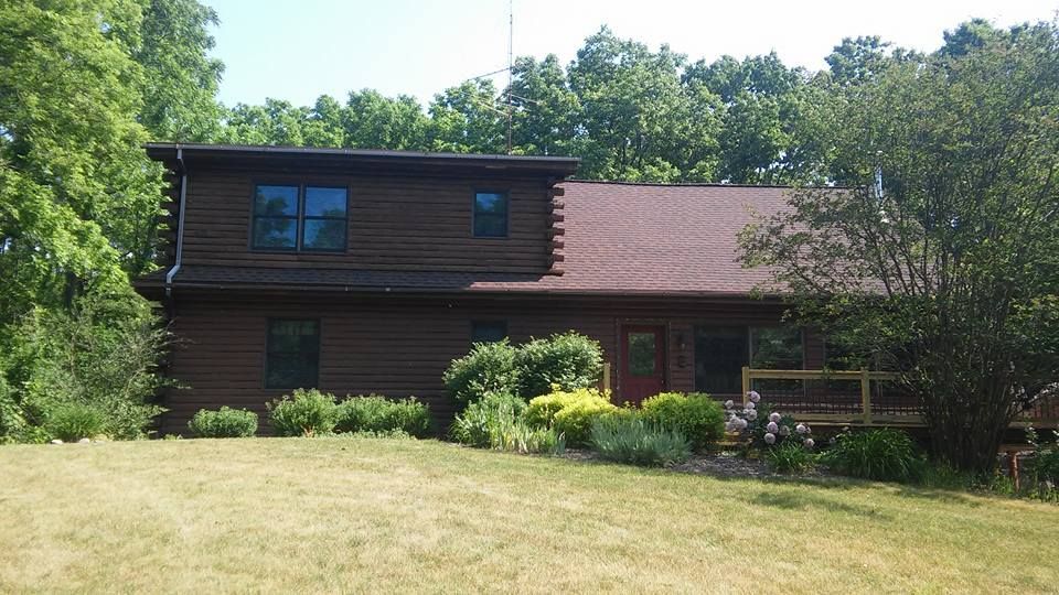 A house with a red roof is surrounded by trees