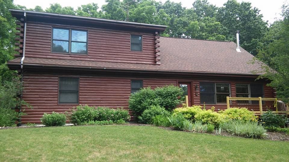 A log cabin with a roof that is covered in shingles