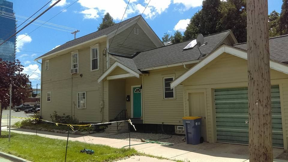 A house with a green door is next to another house