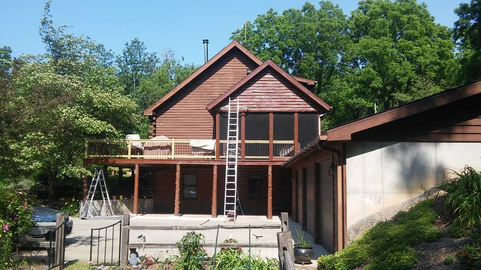 A house with a screened in porch and a ladder in front of it
