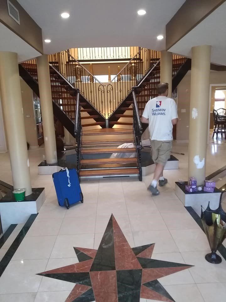 A man walking down a staircase with a blue suitcase