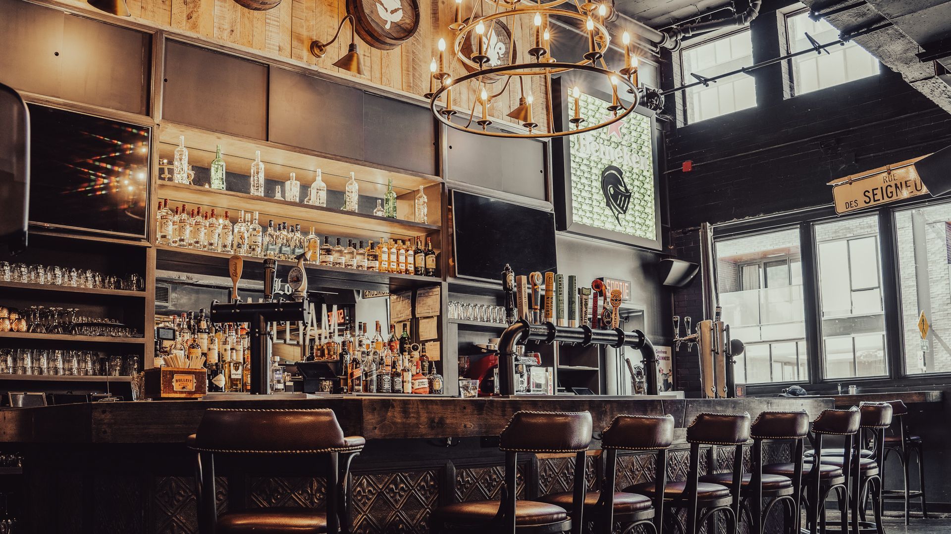 A bar with a long counter and stools in a restaurant.