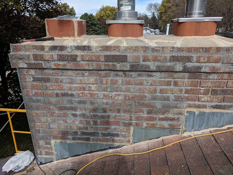 Job located in Council Bluffs, Iowa . 
We had to overlay the deteriorated brick chimney with galvanized wire lath and then applied 3 coats of traditional stucco and a color finished coat.