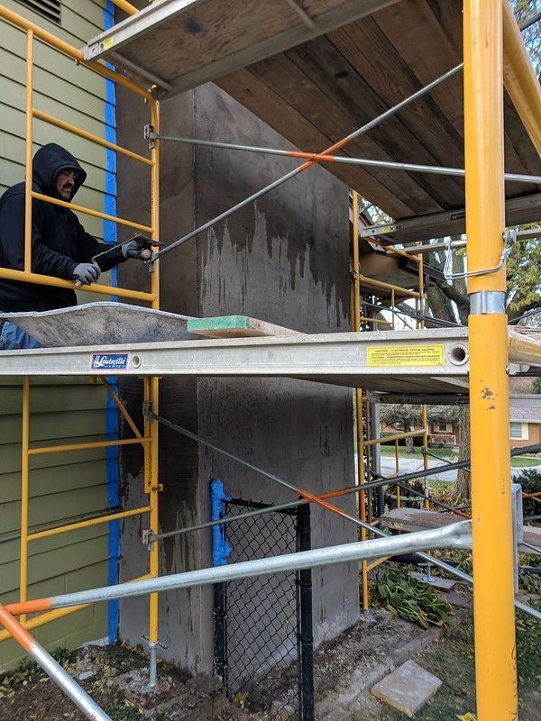 Job located in Council Bluffs, Iowa . 
We had to overlay the deteriorated brick chimney with galvanized wire lath and then applied 3 coats of traditional stucco and a color finished coat.