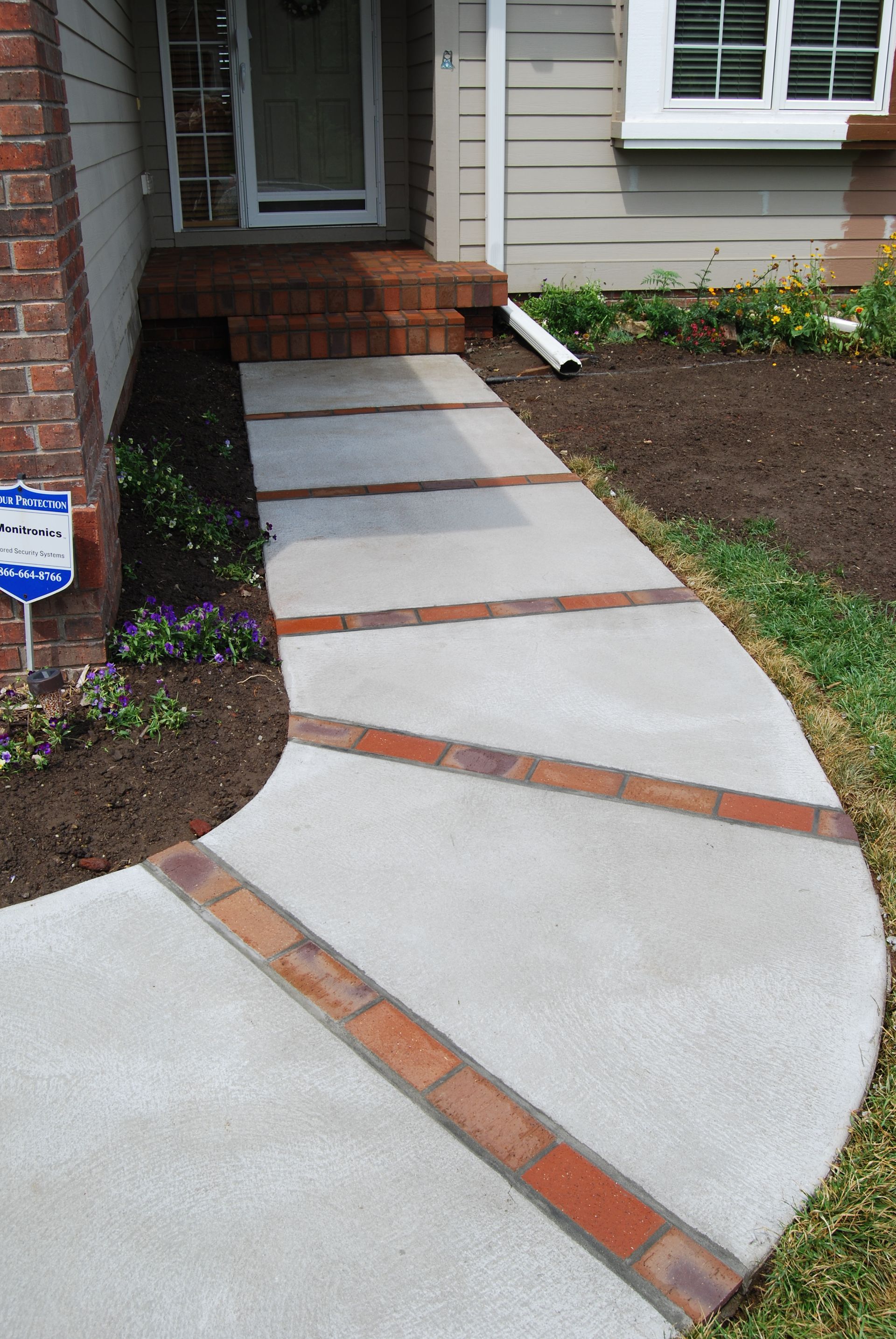 New concrete sidewalk with brick ribbon inlays. This home is located in Golden Hills addition in Crescent Iowa