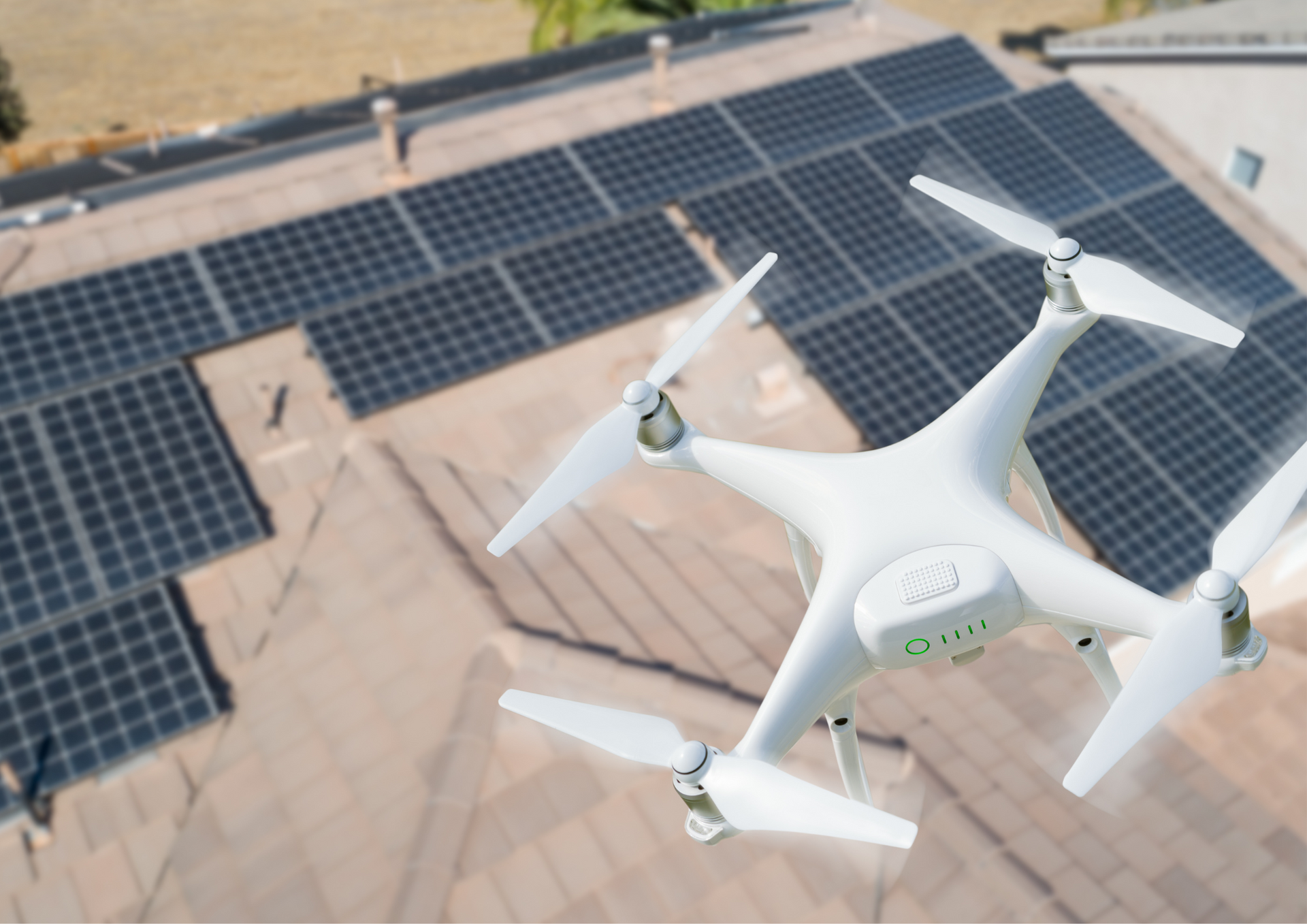 A drone is flying over a solar panel roof.