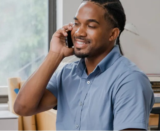 Um homem de camisa azul está falando ao celular