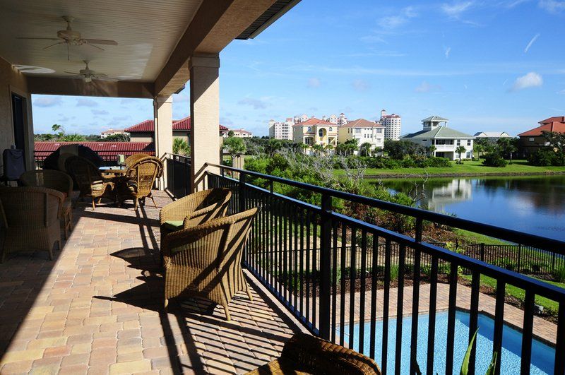 A balcony with chairs and a view of a lake