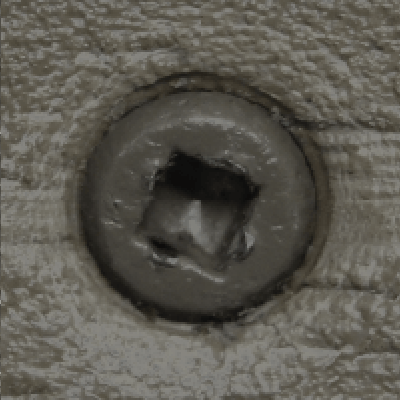 A close up of a screw on a piece of wood.