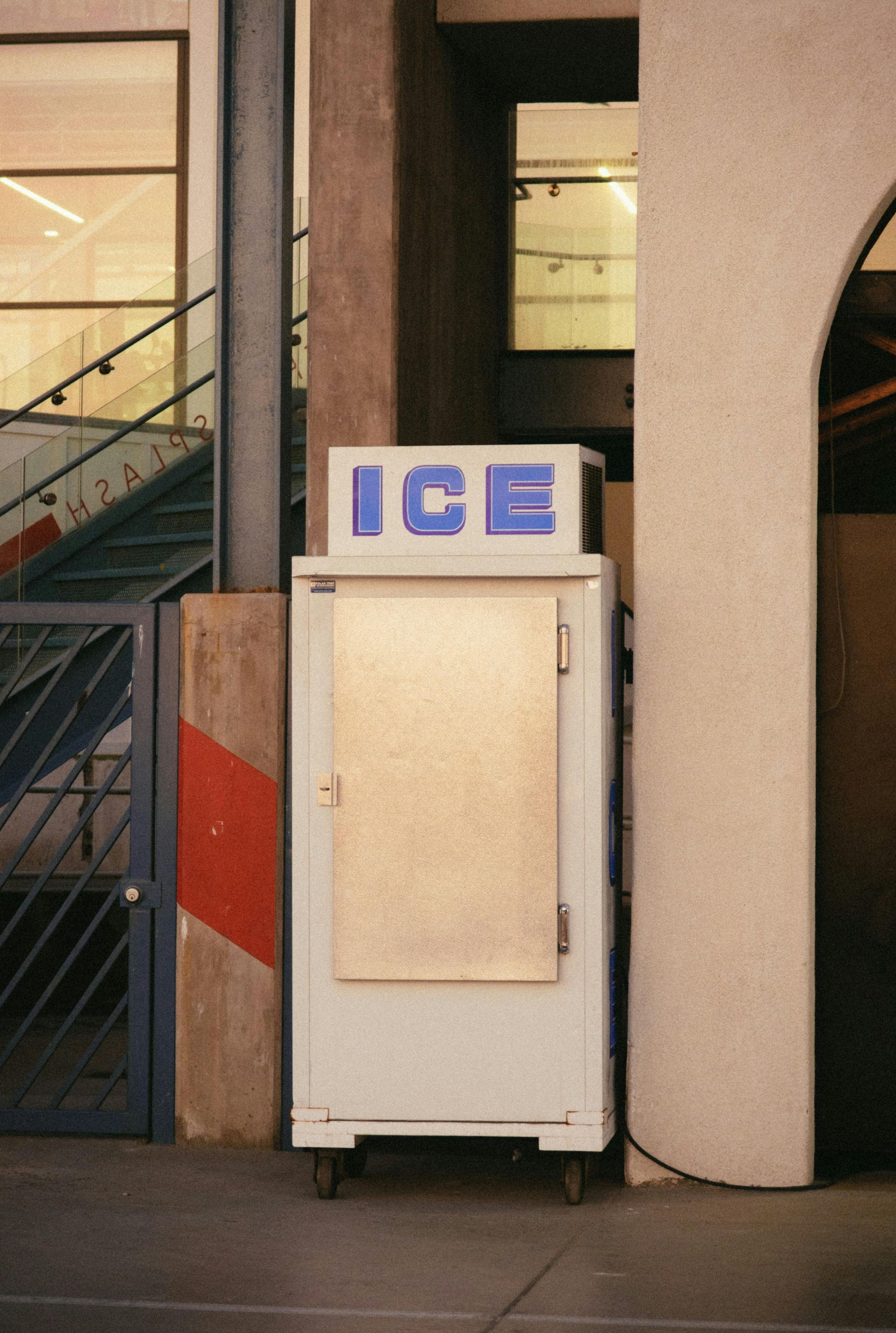 A small ice machine is sitting outside of a building
