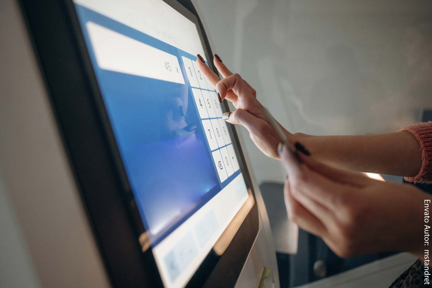 Eine Frau berührt mit ihren Fingern einen Computerbildschirm.