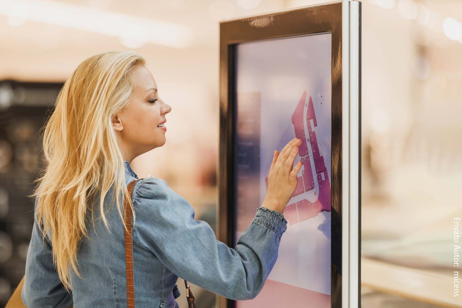Eine Frau berührt in einem Geschäft einen Bildschirm.