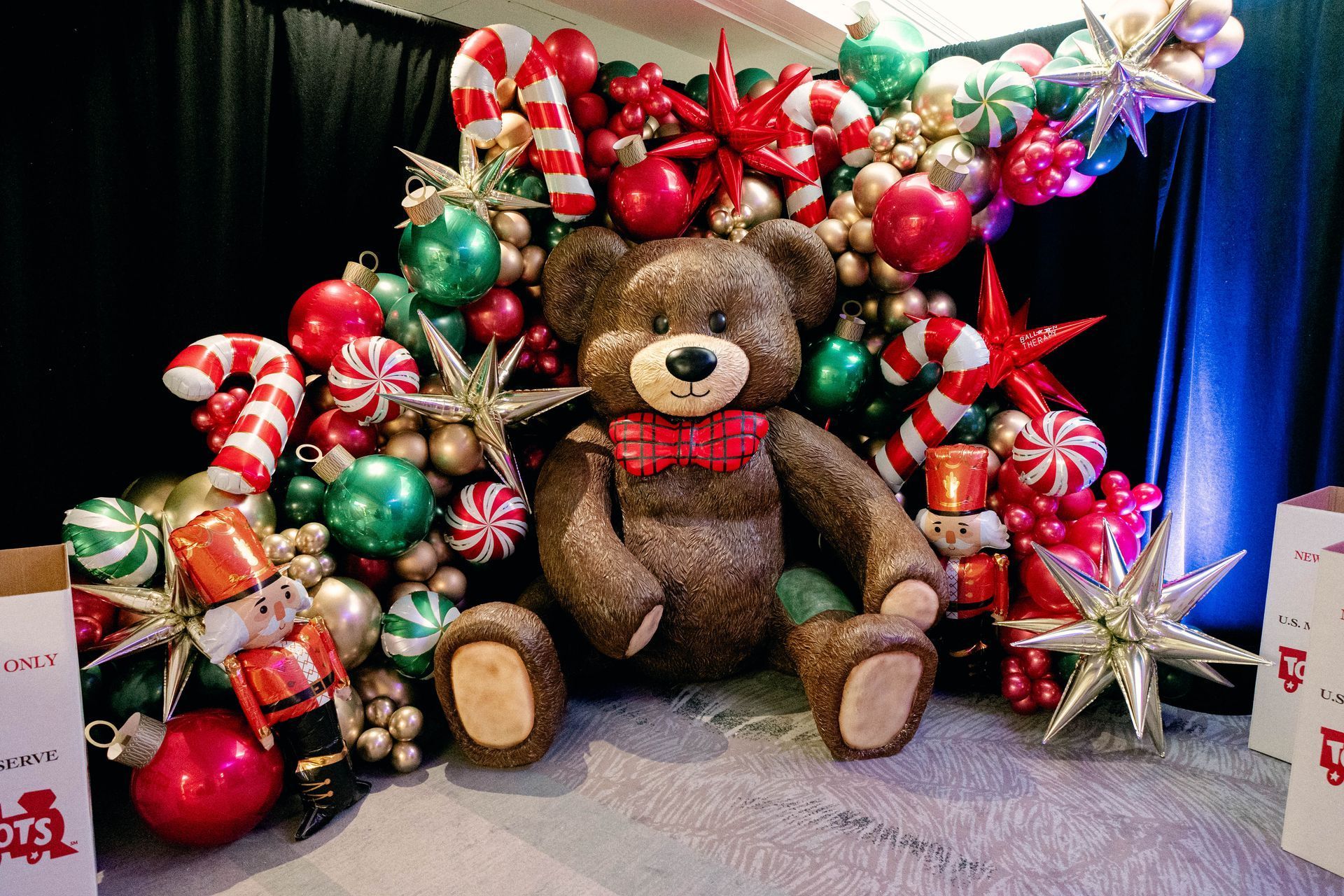 Brown teddy bear surrounded by Christmas ornaments and toy soldiers.