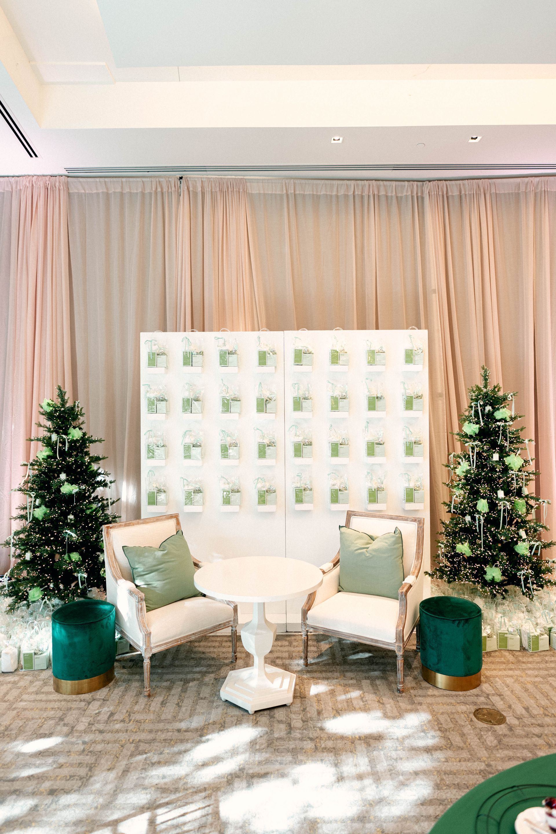Elegant event seating with Christmas trees, a white table, chairs, and a seating chart.