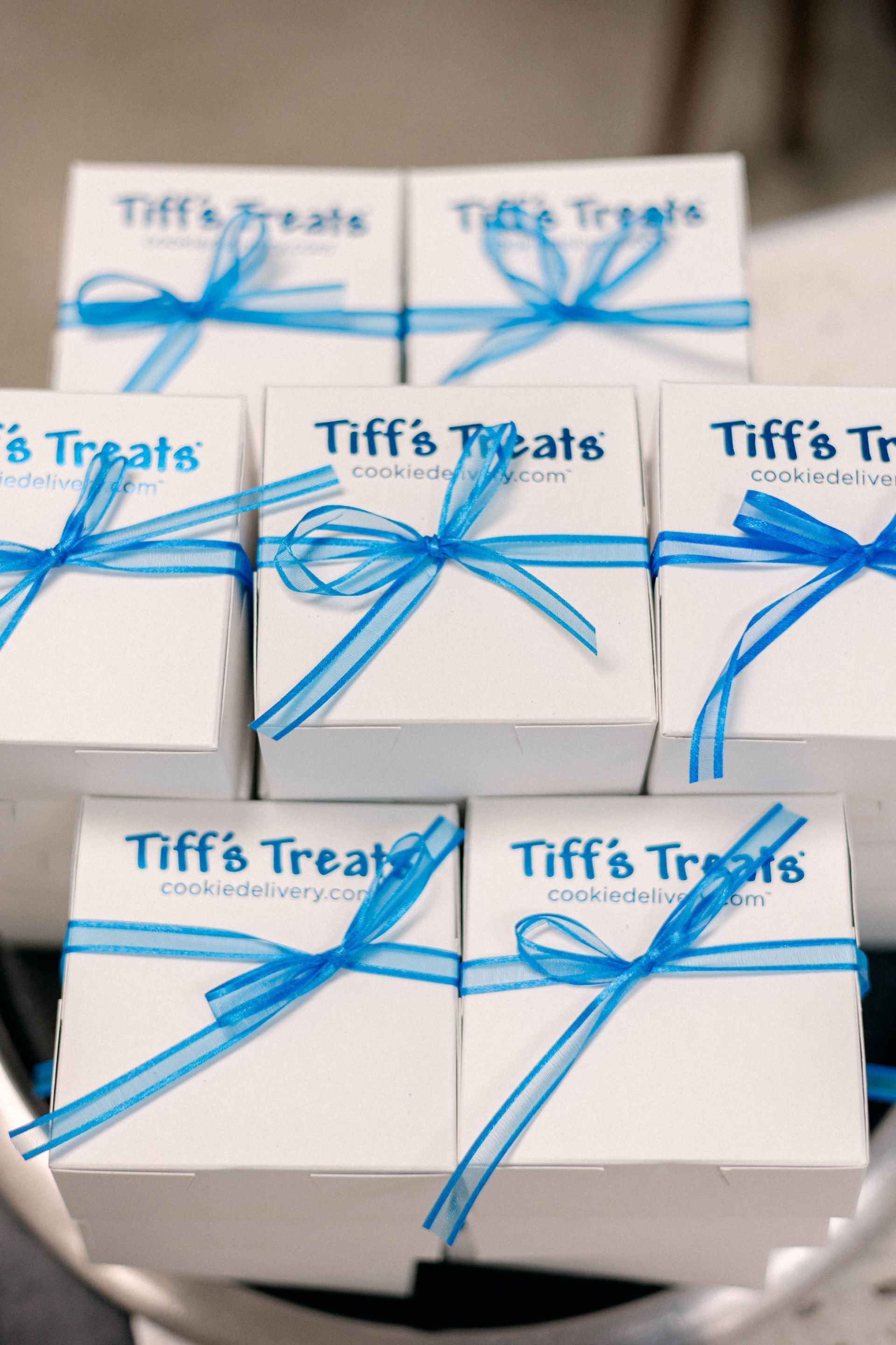 White Tiff's Treats boxes tied with blue ribbon. Stacked and arranged.