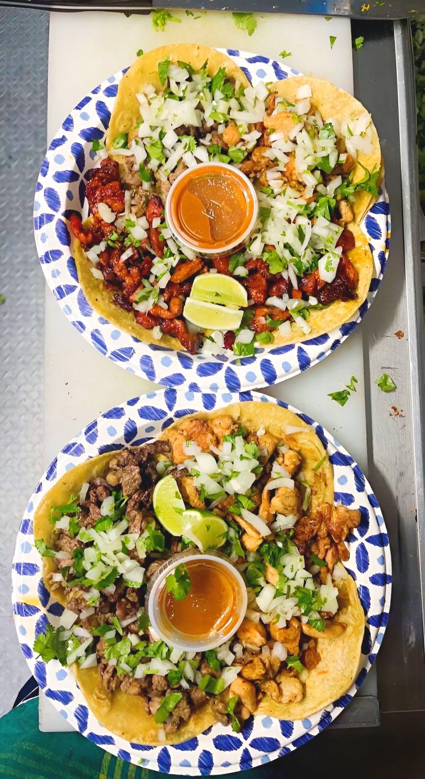 Two plates of tacos are sitting on a table.